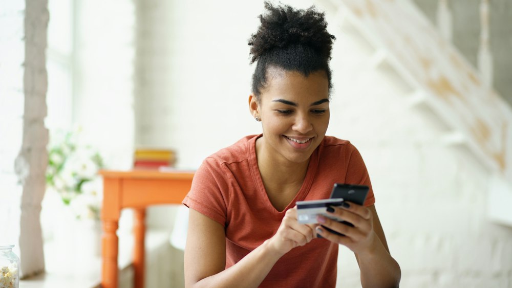 A happy customer checking her savings on her phone